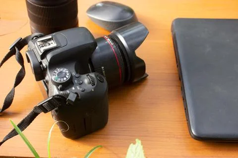 Camera and laptop placed on a brown table Stock Photos