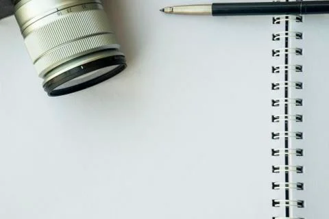 Camera and pen placed on the notebook Stock Photos