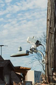 Camera and street light setup on a utility pole against a cloudy sky in an .. 스톡 사진