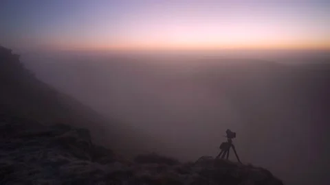 A camera and tripod in pink cloudy landscape 動画素材 234928989