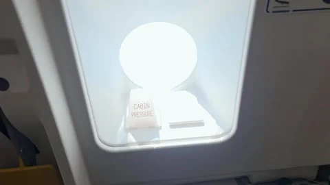 Camera approaches an airplane emergency exit door and peers through the win.. Stock Footage 345166204
