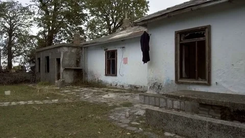 Camera is approaching to abandoned house in forest, broken doors and windows Stock Footage 84847351