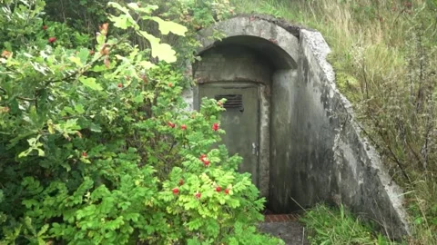 Camera approaching old military bunker entrance Stock Footage 292924316