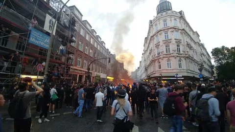 Camera approaching scary sounding chants during violent fiery riot in Europe Stock Footage 92643729