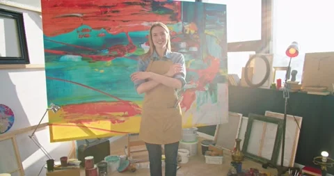 Camera approaching young happy Caucasian female talented painter in apron Stock Footage 149571374