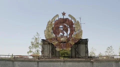 Camera ascends over rusty hammer and sickle sign on rooftop in Pripyat, Stock Footage 115740304