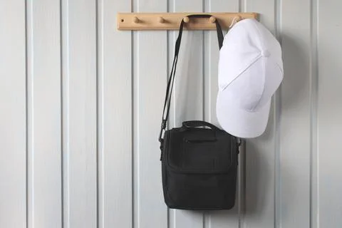 Camera bag and a baseball cap on a wooden hanger. Foto stock