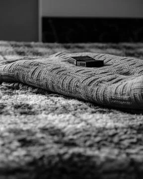 Camera Batteries Resting on a Soft Blanket on a Bed Displaying Photography Fotos de archivo