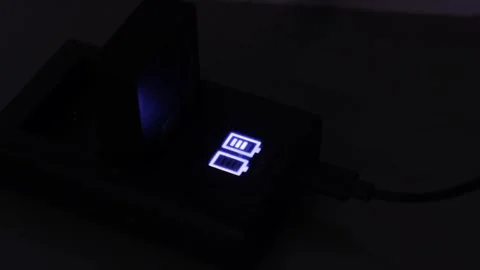 Camera Battery Charging in Dual USB Charger with Illuminated LCD Status Display 스톡 동영상 330480084