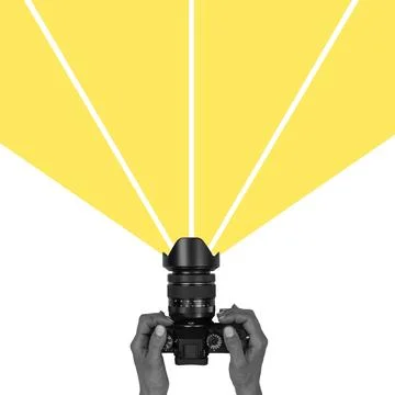 Camera being held with light beams projecting from the lens Stock Photos