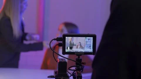 Camera on a blurred background of a female makeup artist applying blush to the Stock Photos