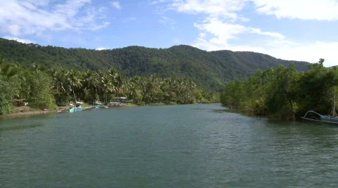 Camera on a boat cruising up river through mangrove and towards outrigger boats Stock Footage 608629