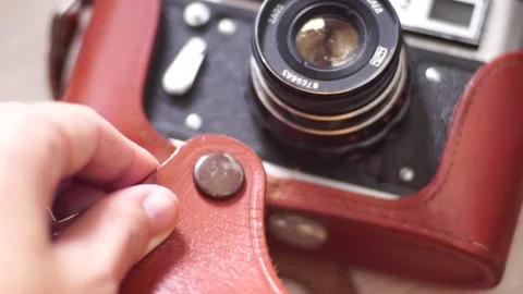 Camera in a brown leather case covered in dust Stock Footage 139688883
