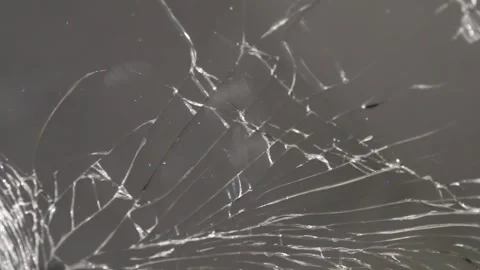 The camera captures a detailed close-up of a cracked glass surface, highlighting Stock Footage 292761460