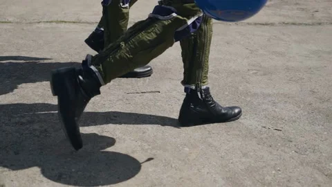 The camera captures the legs of the fighter pilots walking along the runway Stock Footage 155211647