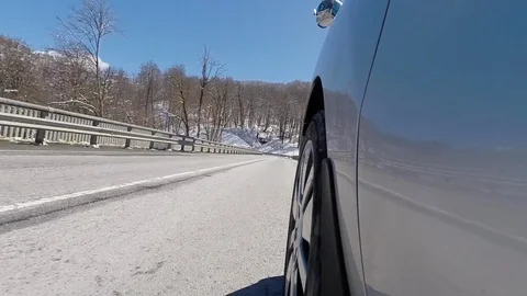 The camera captures the movement of the car at the level of the wheel Mountain Vidéo 106355530
