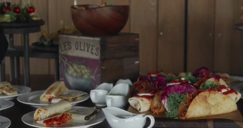 The camera captures a panorama of a table with Mexican dishes on it. Stock Footage 306329870