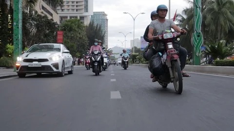 Camera captures passing motorbikes on the road in Nha Trang Stock Footage 124916665