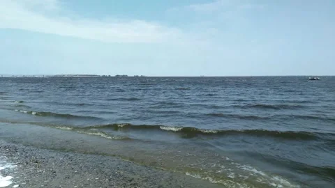 The camera captures a peaceful beach scene as gentle waves rhythmically lap Video stock 292757964