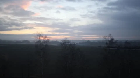 The camera captures a peaceful dawn over vast fields. Soft pink and orange hues  스톡 동영상 300541349