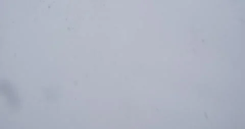 The camera captures the serene dance of snowflakes, as they cascade gently from Stock-Footage 253643478