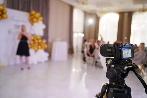 Camera captures speaker at festive event in elegant hall Stock Photos