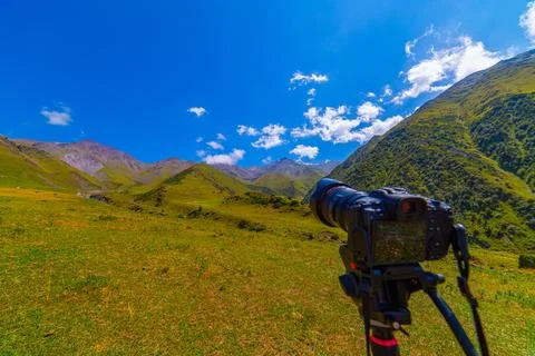 Camera Capturing Scenic Mountain Landscape on Tripod, focus on landscape Фото