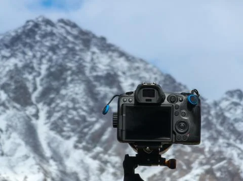 Camera capturing serene mountains during daytime outdoors Photos