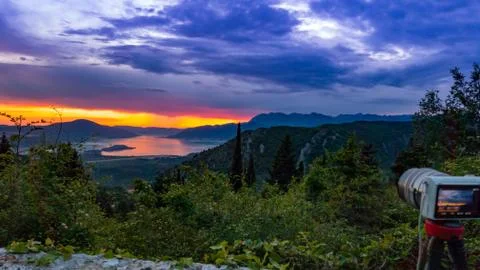 Camera capturing sunset shot. Photography using on tripod against sun rays wi Stock Photos