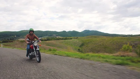 Camera car shot. Man riding red motorcycle in beautiful landscape in Tuscany Stock Footage 239028060