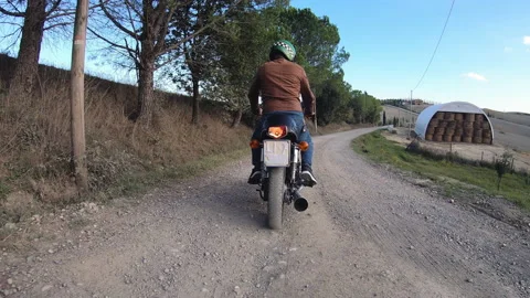 Camera car shot. Man starting and riding red motorcycle in beautiful landscape 스톡 동영상 235812225