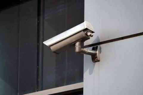 Camera CCTV on the facade of a modern office building on the street, security Stock Photos