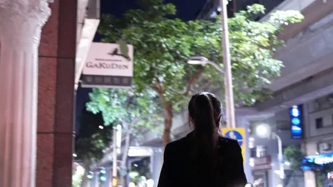 Camera chasing commuter crossing street and playing phone Stock Footage 85292242