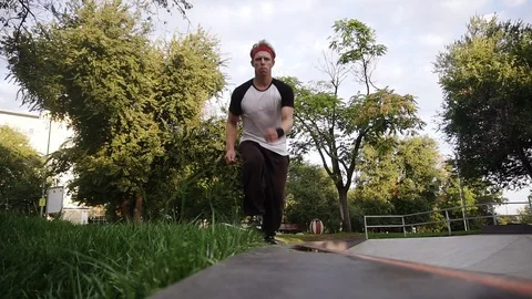 Camera chasing the parkour man performs free running stunt jumps In slow motion Stock Footage 117233904