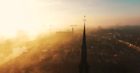 The camera circles around a cross on top of a Christian church covered in fog Video stock 63617049