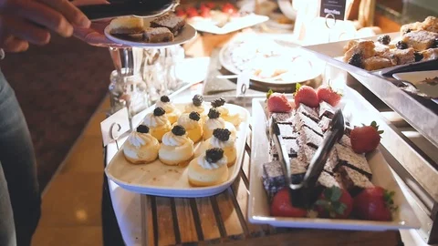 Camera circles around dessert buffet as woman chooses Stock Footage 107394247
