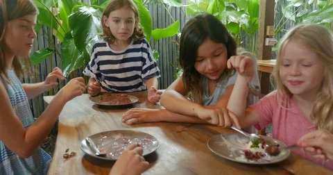Camera circles around a diverse group of young girls eating cake and ice cream Stock Footage 85373433