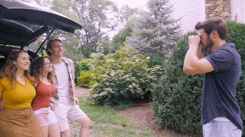 Camera circles around a young man taking a photo of his attractive friends Video stock 120639287