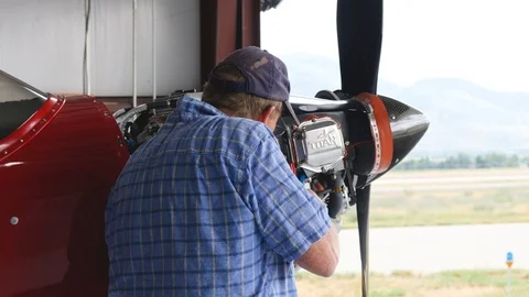 Camera circling around aircraft engine and maintenance man Video stock 116773679