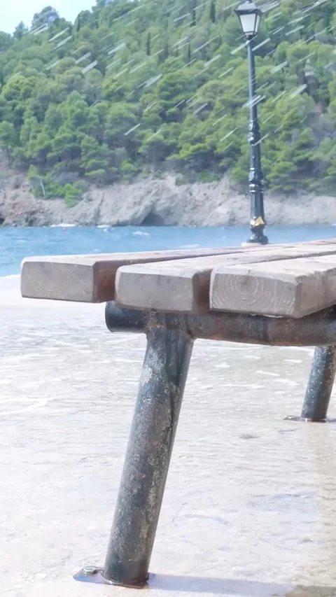 Camera circling around bench partially submerged by ocean Stock-Footage 294963957
