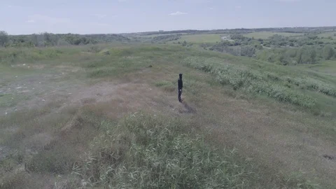 Camera circling around a man standing on the top of a hill and lifting his arms Stock Footage 88101221