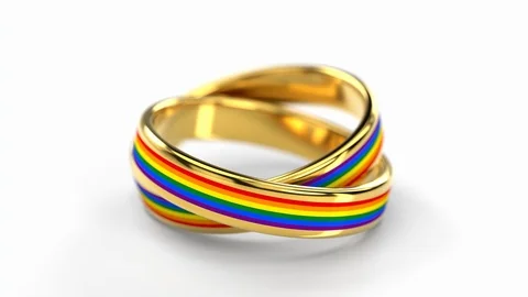 Camera circulating around two connected together wedding rings with rainbow f 스톡 동영상 108378560