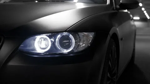 Camera circulating front head lights of black stealth dark BMW sports car Stock Footage 145457145