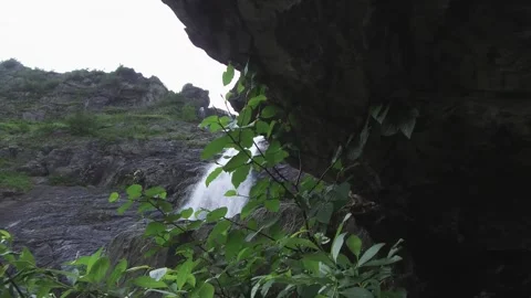 Camera comes out of the rock and shows the waterfall. Ural. Stock Footage 269573032