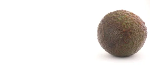 Camera is coming to slowly rotating avocado, isolated on white background. Stock Footage 88631100