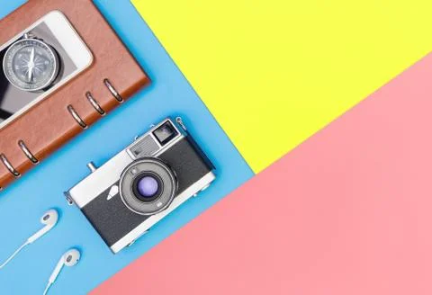 Camera compass diary on blue and yellow pink background Stock Photos