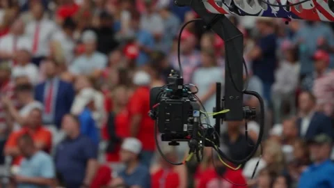 A camera crane moves above the crowd at the Charlie Kirk memorial service Stock Footage 345297975