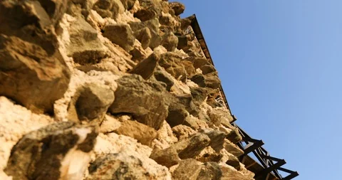 Camera crane shot of irregularly shaped stone wall of stone medieval castle Stock Footage 118540680