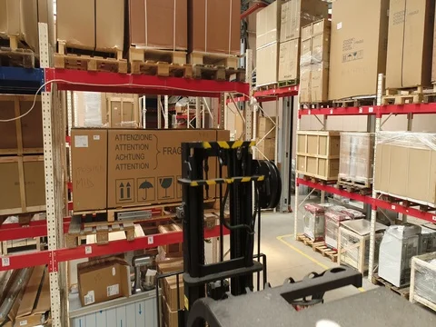 Camera cranes up on shelves of cardboard boxes inside a storage warehouse Stock Footage 79976487