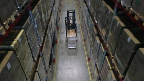 Camera cranes up on shelves of cardboard boxes inside a storage warehouse. Stock Footage 85746170